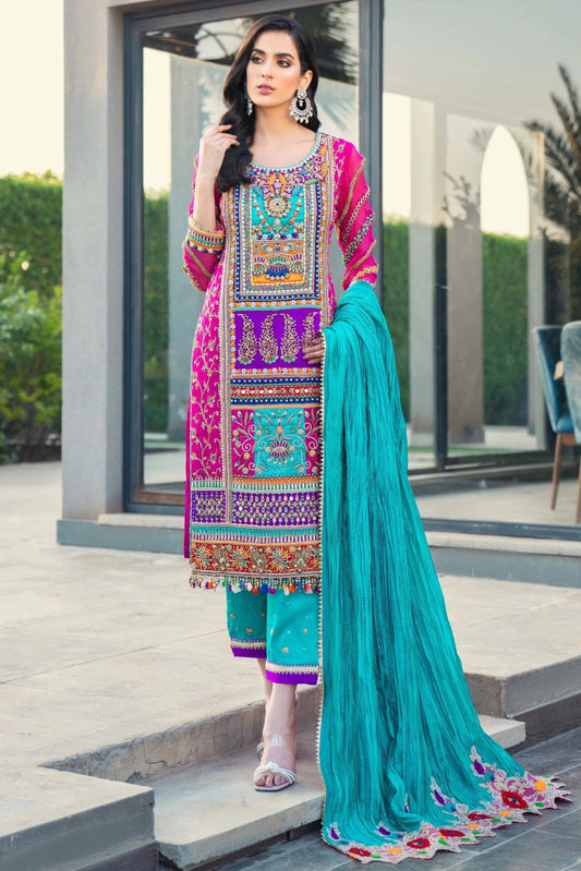 Woman in traditional outfit with colorful embroidery standing outside a modern building.